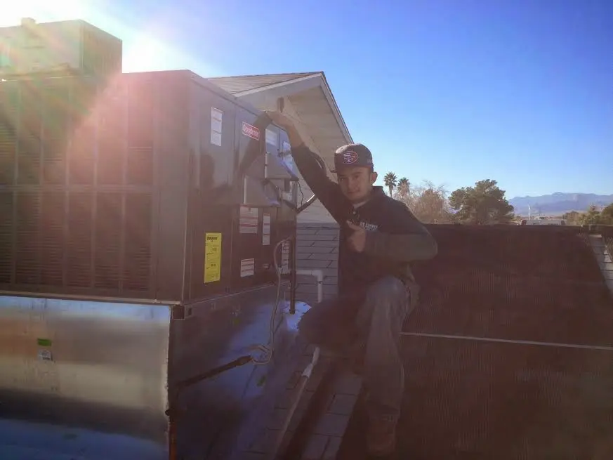 HVAC technician performing Boiler Repair on a rooftop unit in Claremont